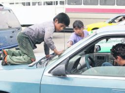 Niños de todas las edades trabajan en los cruceros de la ciudad limpiando parabrisas o vendiendo chicles a cambio de unas monedas.  /