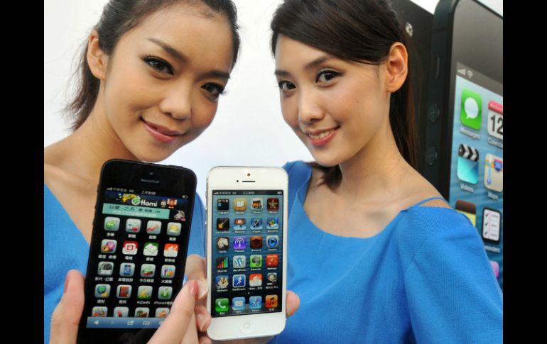 Dos modelos muestran al iPhone 5 durante el lanzamiento del producto en una tienda en Taipei. ARCHIVO  /