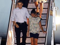 El presidente Barack Obama llega a Honolulu, con su esposa Michelle Obama y sus hijas Malia y Sasha. AP  /