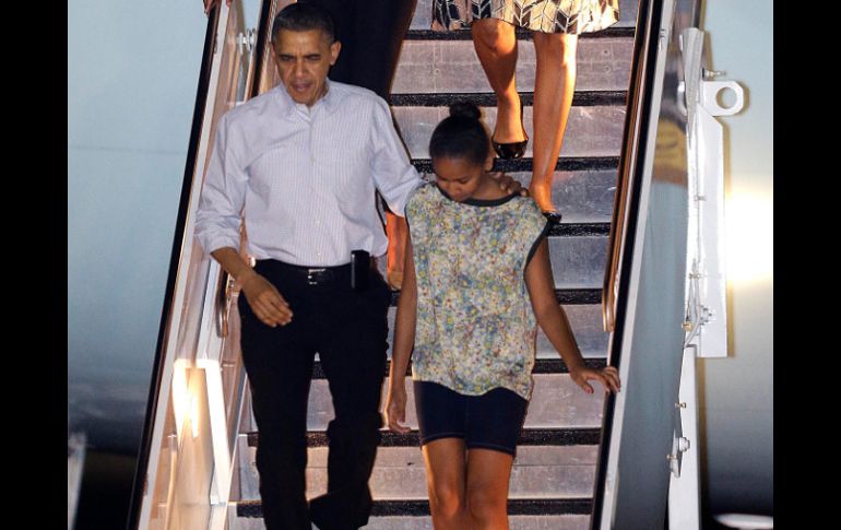 El presidente Barack Obama llega a Honolulu, con su esposa Michelle Obama y sus hijas Malia y Sasha. AP  /