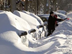 Dos vecinos se dan a la tarea de quitar la nieve de encima de sus automóviles hoy, tras la nevada en Montreal. REUTERS  /