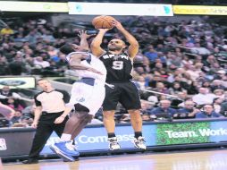 De larga distancia. Tony Parker lanza un triple, mientras Darren Collison intenta bloquear el tiro del francés. AFP  /