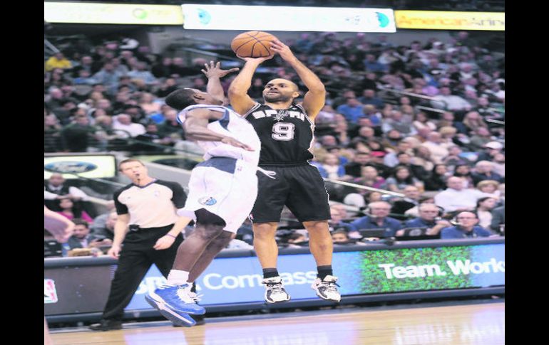 De larga distancia. Tony Parker lanza un triple, mientras Darren Collison intenta bloquear el tiro del francés. AFP  /