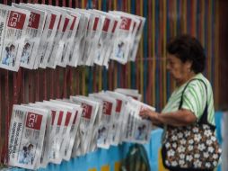 Una mujer toma hoy un periódico con información sobre el presidente de Venezuela, Hugo Chávez. EFE  /