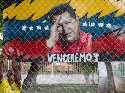 Un hombre cuelga un cartel alegórico al presidente de Venezuela, Hugo Chávez. EFE EFE /