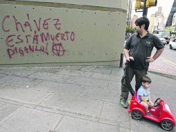 Un hombre observa graffitis en una avenida de Caracas, donde presionan al Gobierno para dar a conocer el estado de salud de Chávez. AFP  /