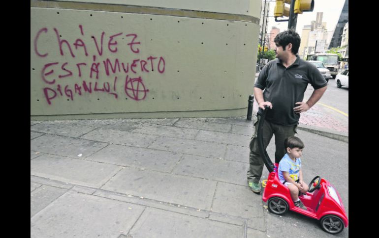 Un hombre observa graffitis en una avenida de Caracas, donde presionan al Gobierno para dar a conocer el estado de salud de Chávez. AFP  /