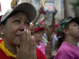 Partidaria de Chávez llora mientras reza por la salud del presidente venezolano. AFP /