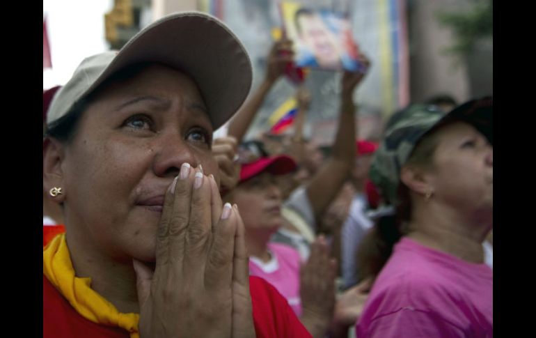 Partidaria de Chávez llora mientras reza por la salud del presidente venezolano. AFP /