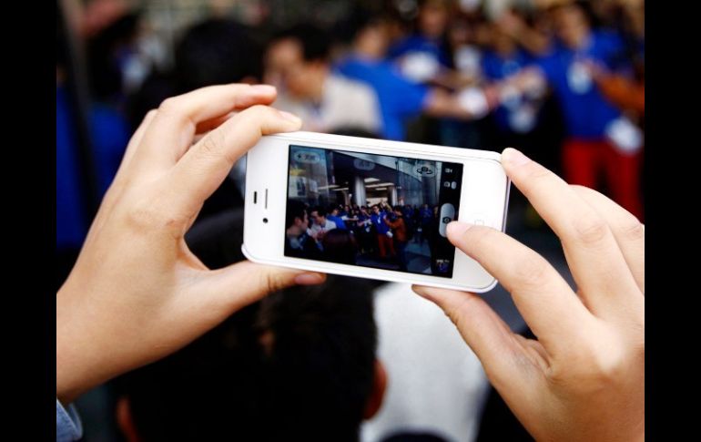 Con un iPhone, es tomada la fotografía de los asistentes a una tienda Apple. REUTERS /