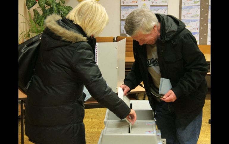 Dos ciudadanos emiten su voto en un centro electoral en Praga. XINHUA /