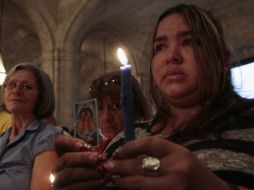 Una mujer sostiene una vela durante una misa en honor a Hugo Chávez REUTERS /