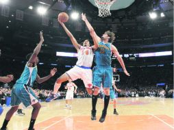 Chris Copeland (14) intenta encestar, ante la marca de Robin López (15), durante el juego en el Madison Square Garden. AP /