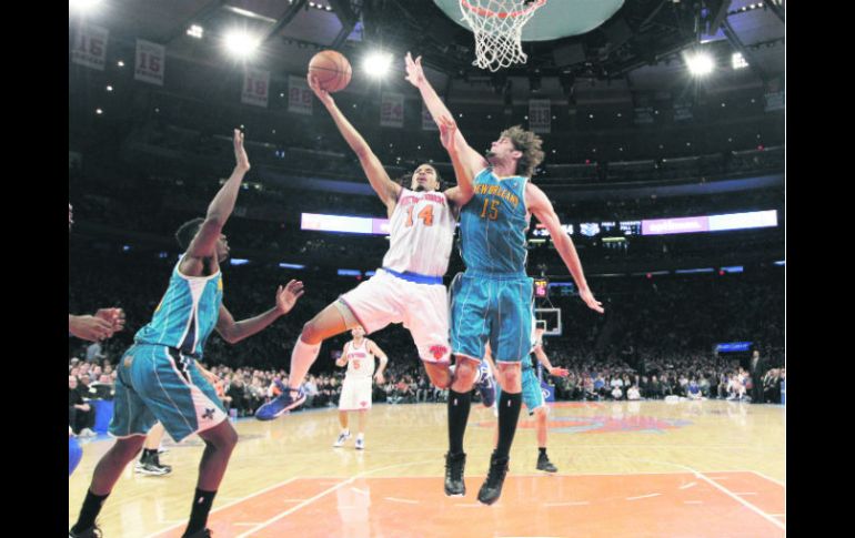 Chris Copeland (14) intenta encestar, ante la marca de Robin López (15), durante el juego en el Madison Square Garden. AP /