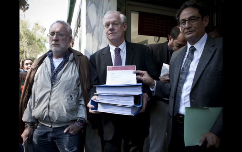 Los activistas entregan a Michael Glover, ministro de Asuntos Políticos (c) la carta con las firmas. XINHUA /