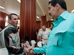 Nicolas Maduro (R) y Henrique Capriles Radonski (C) se saludan durante un evento. EFE /