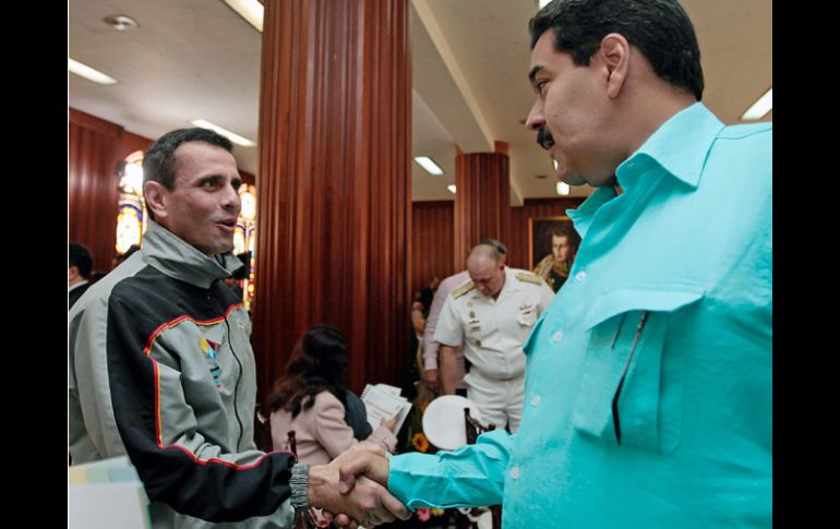 Nicolas Maduro (R) y Henrique Capriles Radonski (C) se saludan durante un evento. EFE /