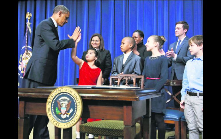 Barack Obama y la niña Hinna Zejah chocan sus manos en señal de acuerdo para frenar la violencia que enluta a Estados Unidos. AP /