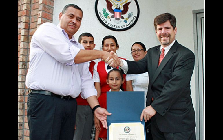 El cónsul Thomas Mittchnat(d) durante entrega de reconocimiento por récord en entrega de visas. ESPECIAL /