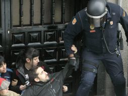 En España, un guardia civil procede a desahuciar a un obrero senegalés que no puede pagar la hipoteca de su piso. EFE /