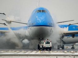 Personal de tierra deshiela un avión de KLM en el aeropuerto de Amsterdam, Holanda. EFE /