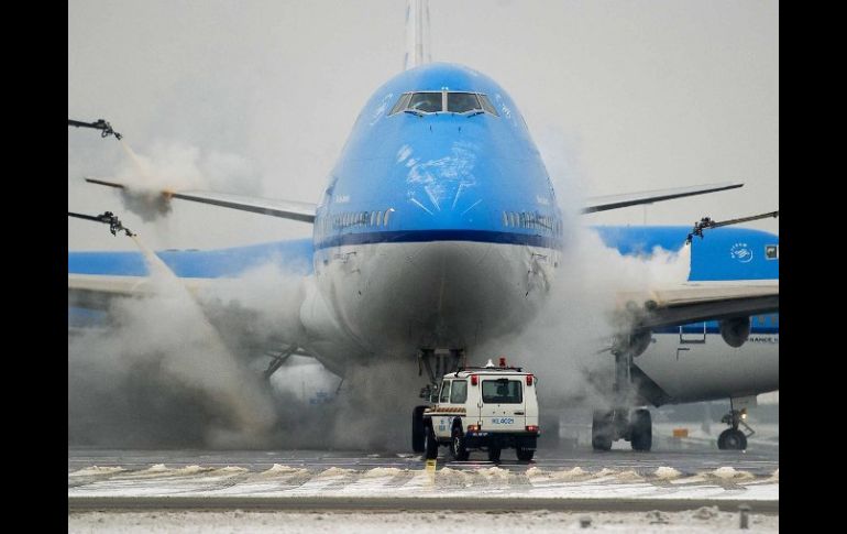 Personal de tierra deshiela un avión de KLM en el aeropuerto de Amsterdam, Holanda. EFE /