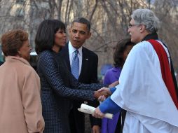 Los Obama son recibidos por el Reverendo Luis León. AFP /