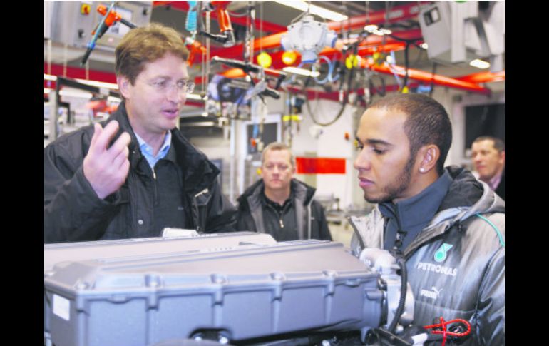 Lewis Hamilton escucha con atención la explicación acerca de un motor Mercedes, durante su visita a la planta en Stuttgart. EFE /
