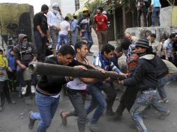 Los manifestantes tratan de derrumbar uno de los muros que conduce a la plaza de Tahrir. EFE /