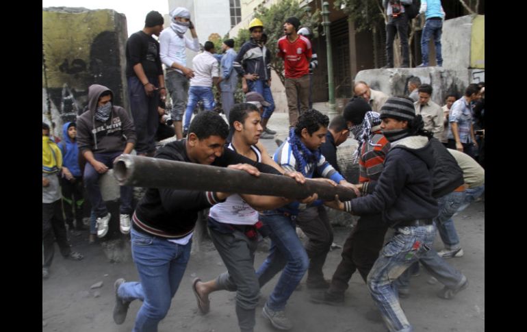 Los manifestantes tratan de derrumbar uno de los muros que conduce a la plaza de Tahrir. EFE /