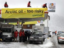 Fotografía que muestra a los activistas encadenados a  la gasolinera de Shell. EFE /