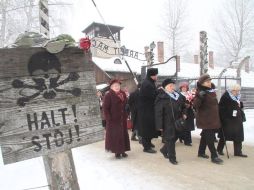 En el 68 aniversario de su liberación, exprisioneros visitan Auschwitz; en la puerta se lee: ''Por el trabajo se logra la libertad''. EFE /