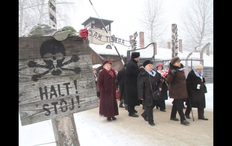 En el 68 aniversario de su liberación, exprisioneros visitan Auschwitz; en la puerta se lee: ''Por el trabajo se logra la libertad''. EFE /