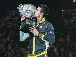 Ya es costumbre. Novak Djokovic besa el trofeo, el cual ha ganado cuatro veces, tres de ellas consecutivas. AFP /