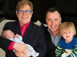 Sir Elton John posa sontriente con su familia. ESPECIAL /