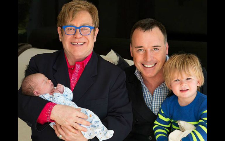 Sir Elton John posa sontriente con su familia. ESPECIAL /