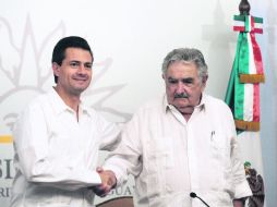 Gira en Montevideo. Peña Nieto estrecha la mano del presidente uruguayo, José Mujica. AFP /