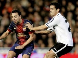 Xavi (izq.) sale lesionado del juego ante Valencia y tardará 15 días en recuperarse. EFE /