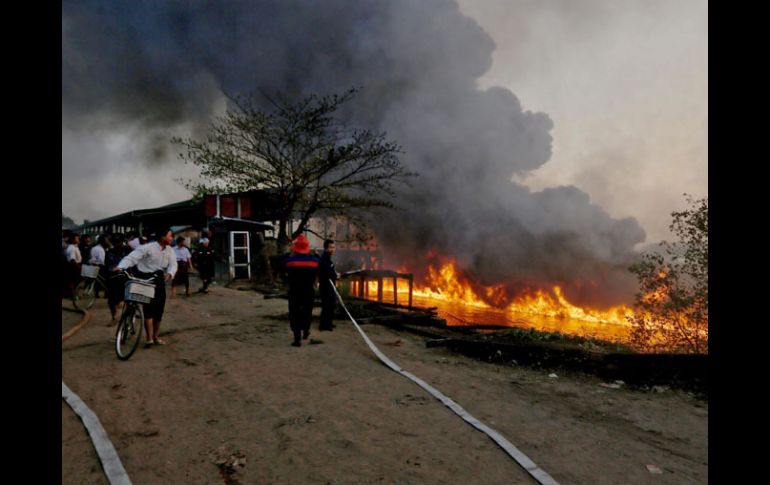 Unos bomberos tratan de apagar un incendio provocado por la explosión de un tanque de gasolina, en Rangún. EFE /