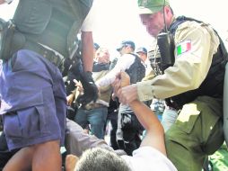 A RAYA. Uniformados someten a un inconforme por obstaculizar el tráfico vehicular. EL INFORMADOR /