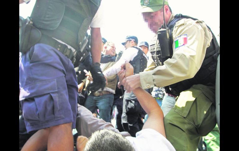 A RAYA. Uniformados someten a un inconforme por obstaculizar el tráfico vehicular. EL INFORMADOR /