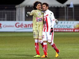 Guillermo Ochoa bromea con Adrián Mutu al terminar el partido. AFP /