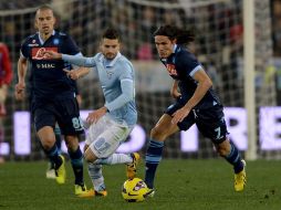 Cavani (der.) se quita la marca de un jugador de la Lazio en el partido. AFP /