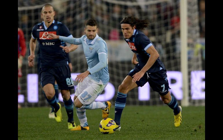 Cavani (der.) se quita la marca de un jugador de la Lazio en el partido. AFP /