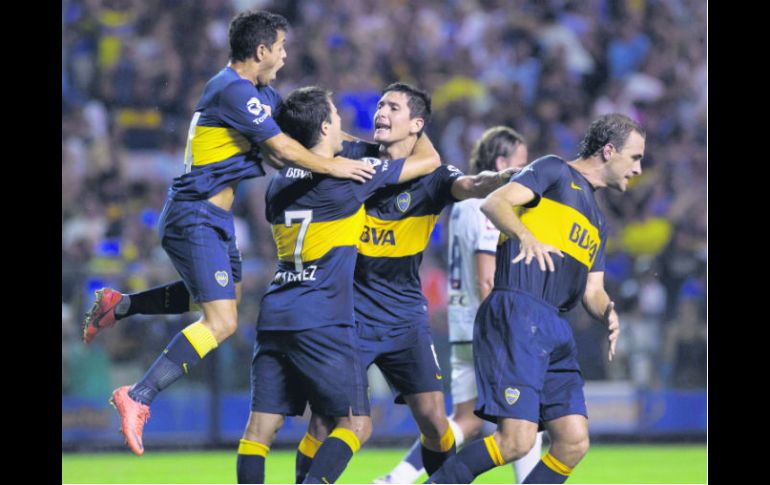 Guillermo Burdisso (centro), quien festeja con sus compañeros, fue la figura del Boca al anotar dos goles en la recta final del partido AP /