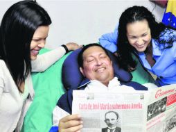 Hugo Chávez acompañado de sus hijas sosteniendo el diario ''Granma'' del 14 de febrero pasado. NTX /