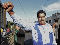 Transeúntes pasan frente a publicidad en apoyo del presidente venezolano, en las afueras del hospital militar. EFE /