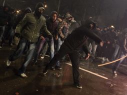 Un manifestante arroja un objeto a unos policías antidisturbios durante los disturbios registrados después de un acto de protesta. EFE /