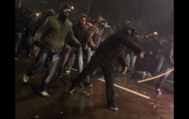 Un manifestante arroja un objeto a unos policías antidisturbios durante los disturbios registrados después de un acto de protesta. EFE /