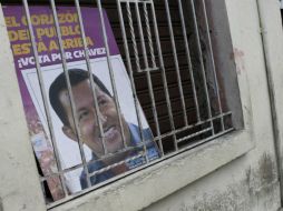 Un póster con la imagen de Chávez es colocado en una ventana en Venezuela. EFE /